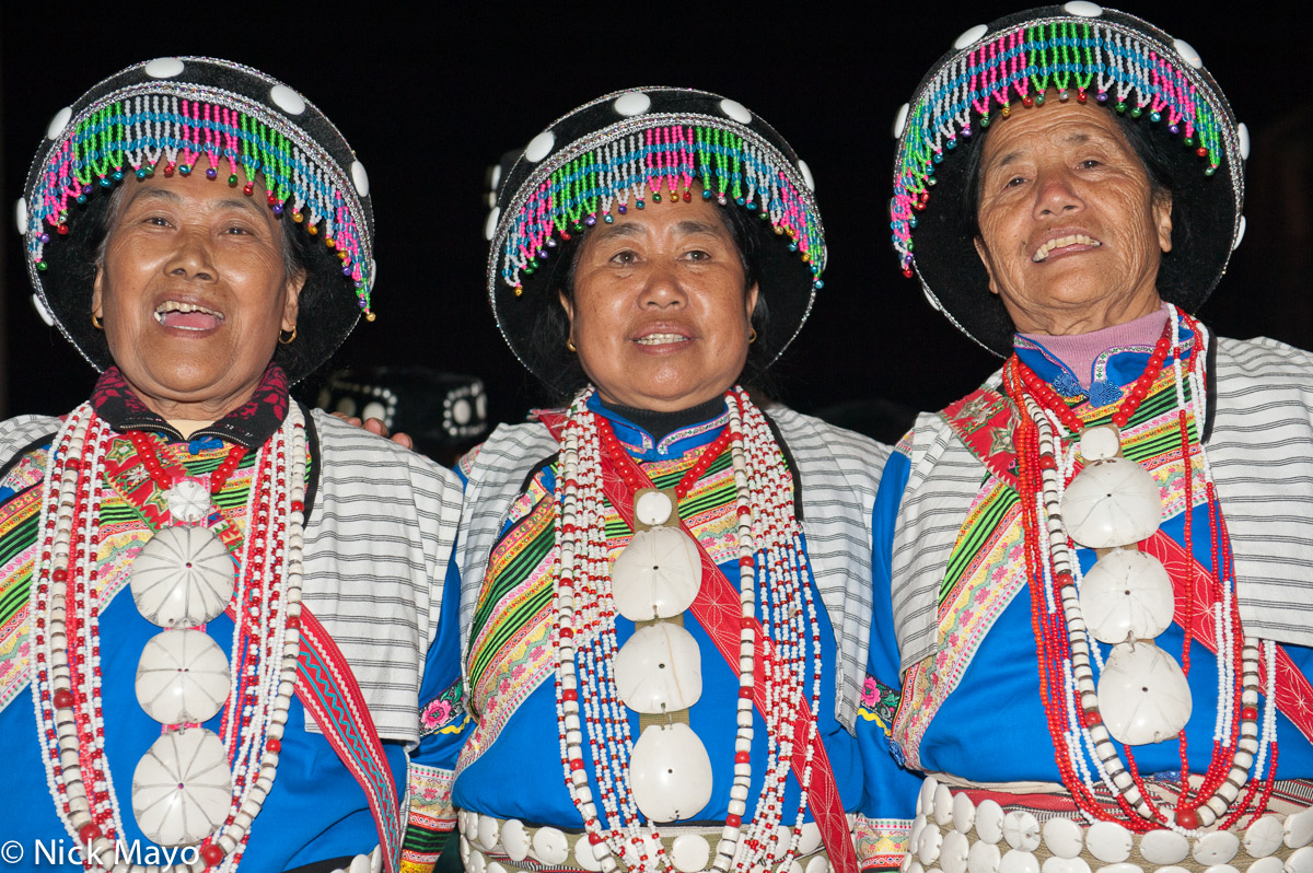 Three Lisu ladies wearing tradtional attire at an evening dance in Liu Ke.
