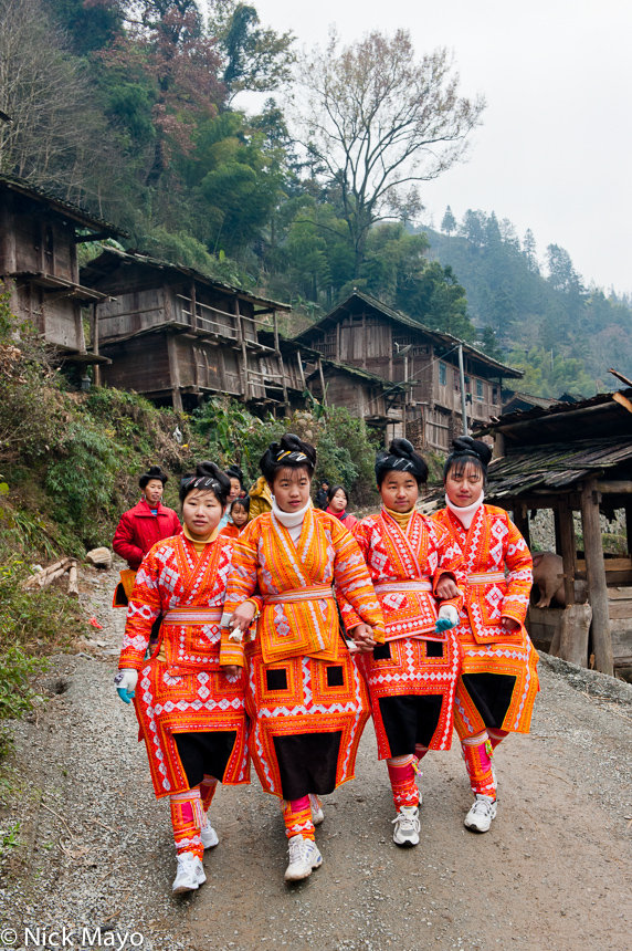Four Miao girls on their way to a wedding in the village of Kazhai.