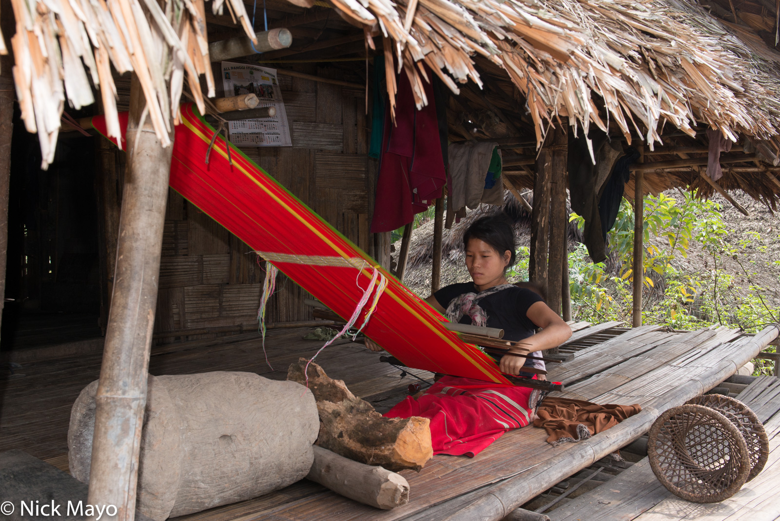 An Adi woman weaving on a back loom in the village of Ponging.