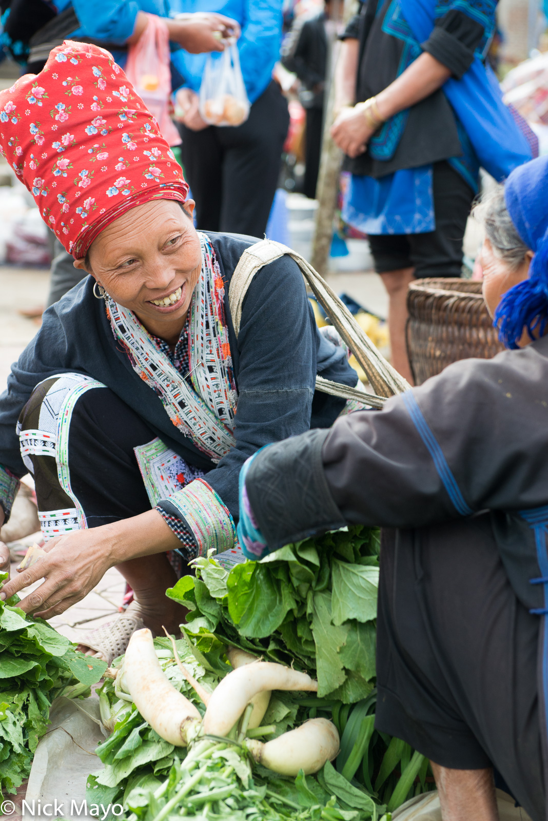 A Red Dao woman buying vegetables at Y Ty market.