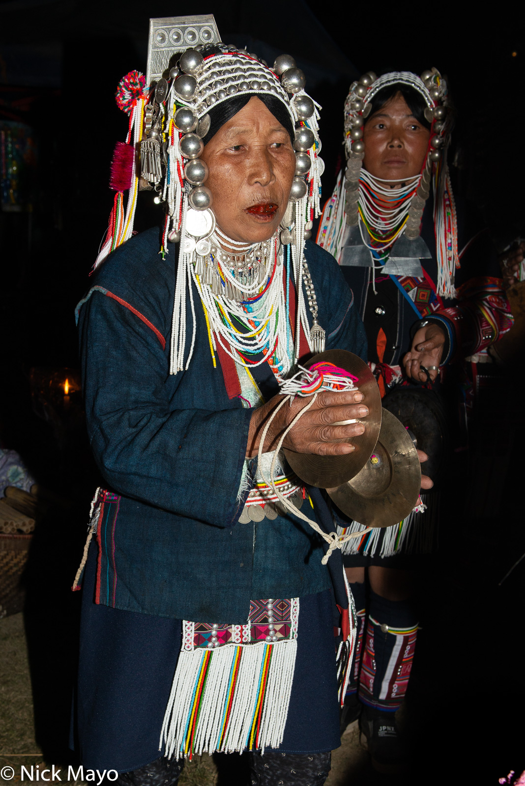 An Akha (Hani) woman circling with cymbals during an impromptu evening dance at a festival in Kengtung.