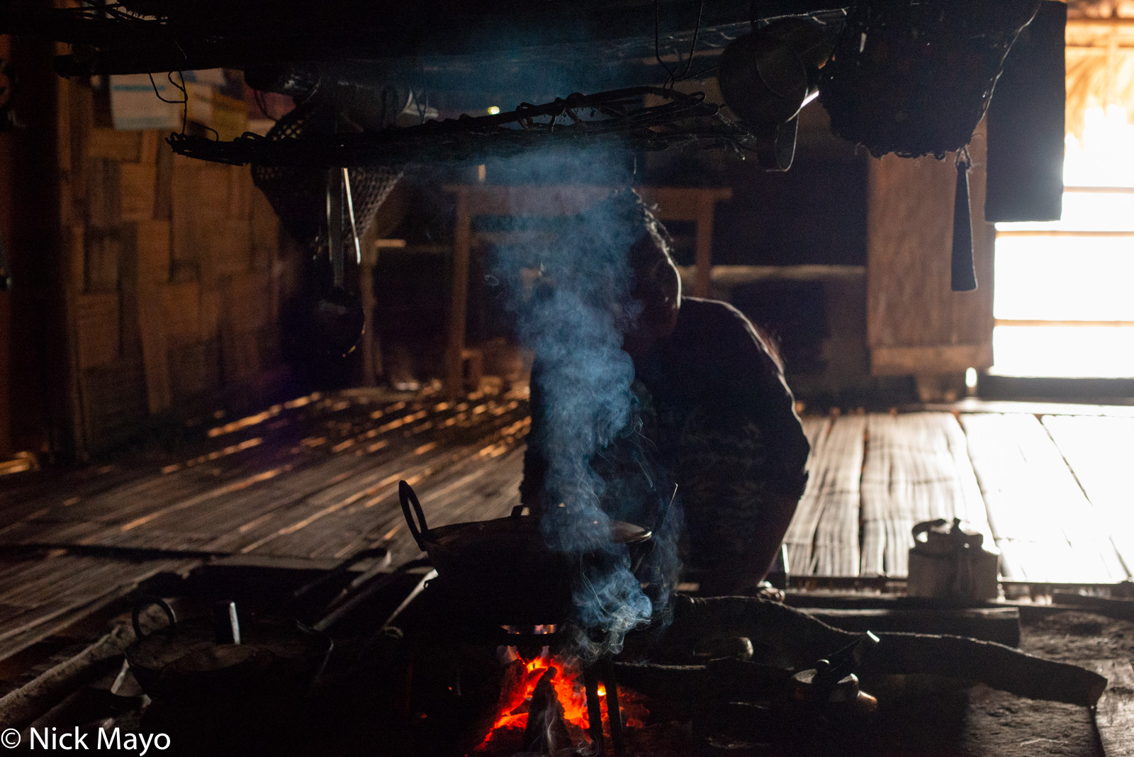 An Adi Minyong woman cooking on her hearth in the Siang valley village of Komshing.