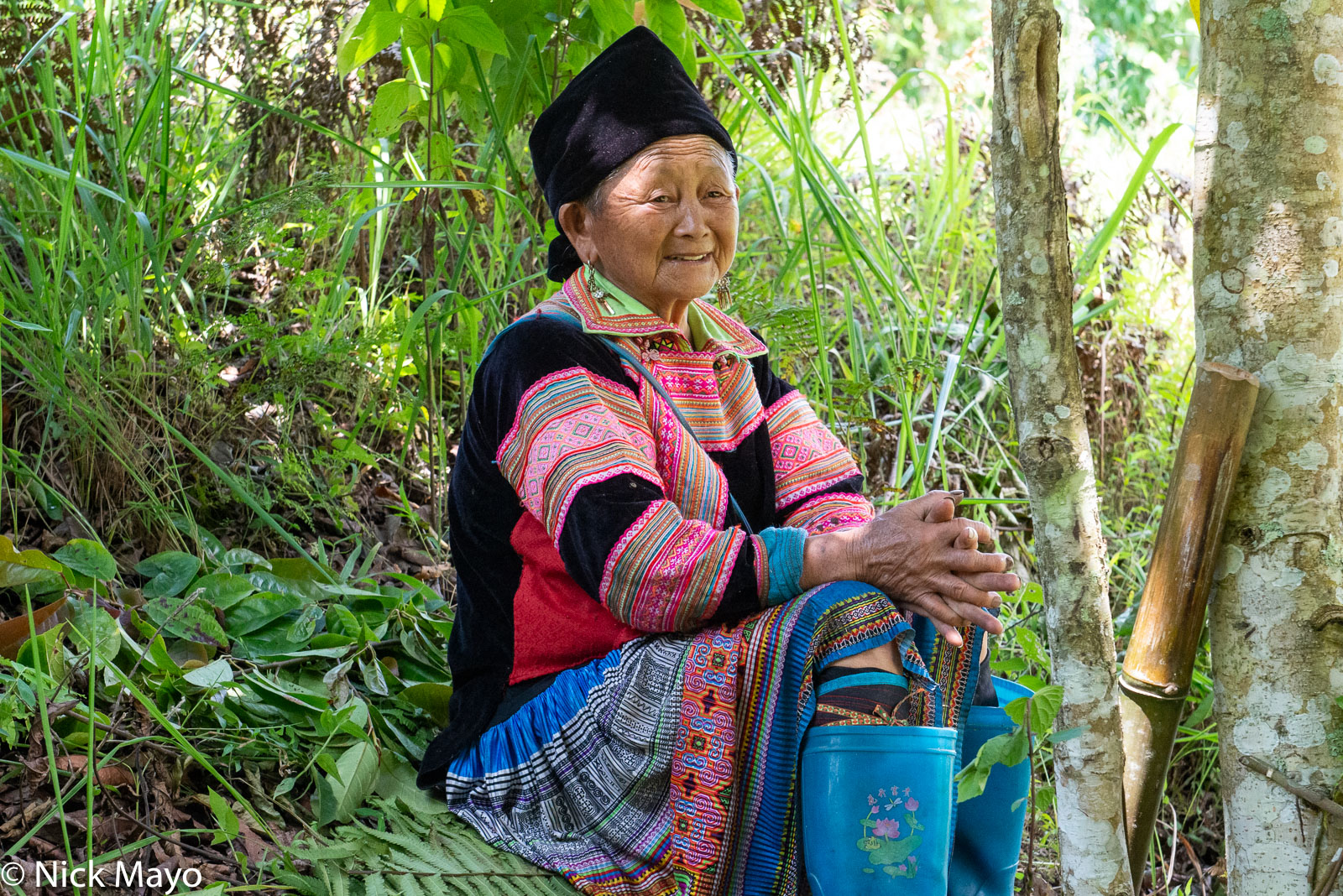 A Flowery Hmong (Miao) woman resting in the shade at Ta su Choong.