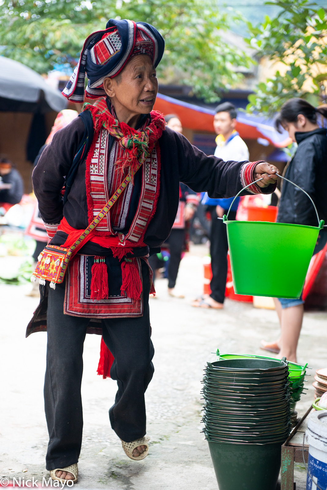 A Red Dao woman shopping for a bucket at Thong Nguyen market.