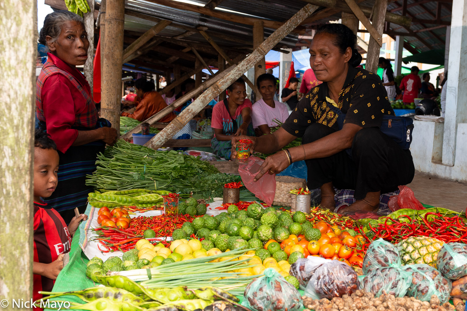 A vendor selling fruit and vegetables at Mataloko market in Ngada Regency.