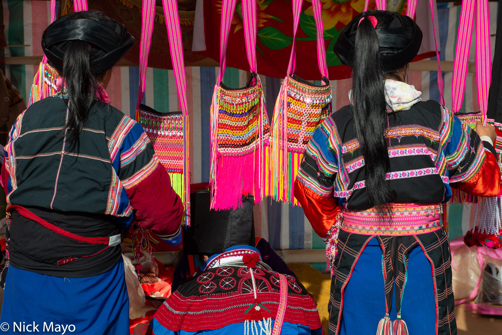 Girls looking to buy traditional bags at a Lisu New Year festival in Mogok.