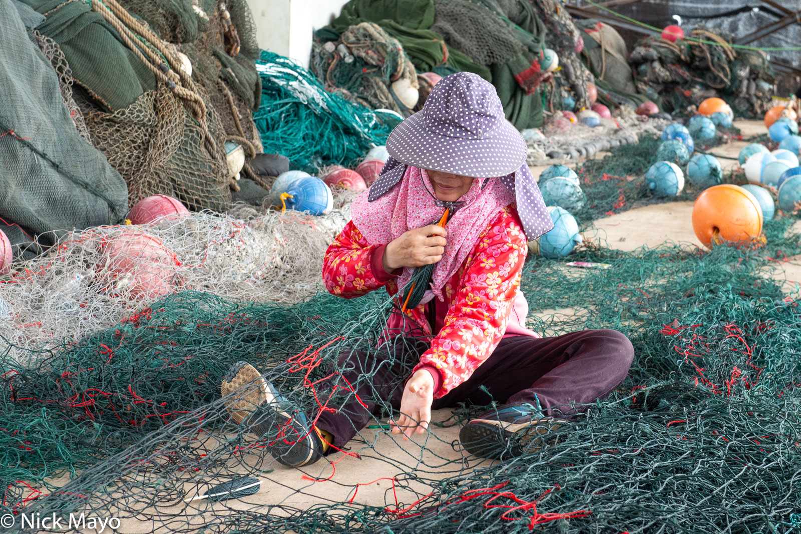Repairing fishing nets at Wai'an port.