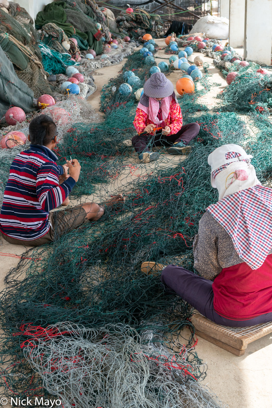 Repairing fishing nets at Wai'an harbour.