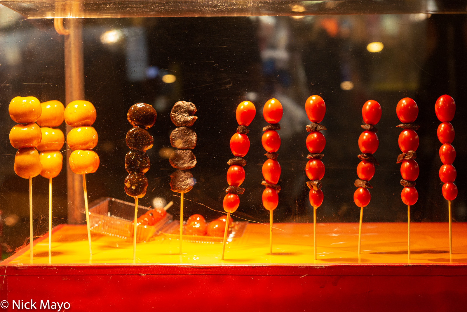 Snacks on sale in a scratched perspex box at a night market stand in Taipei's Wanhua district.