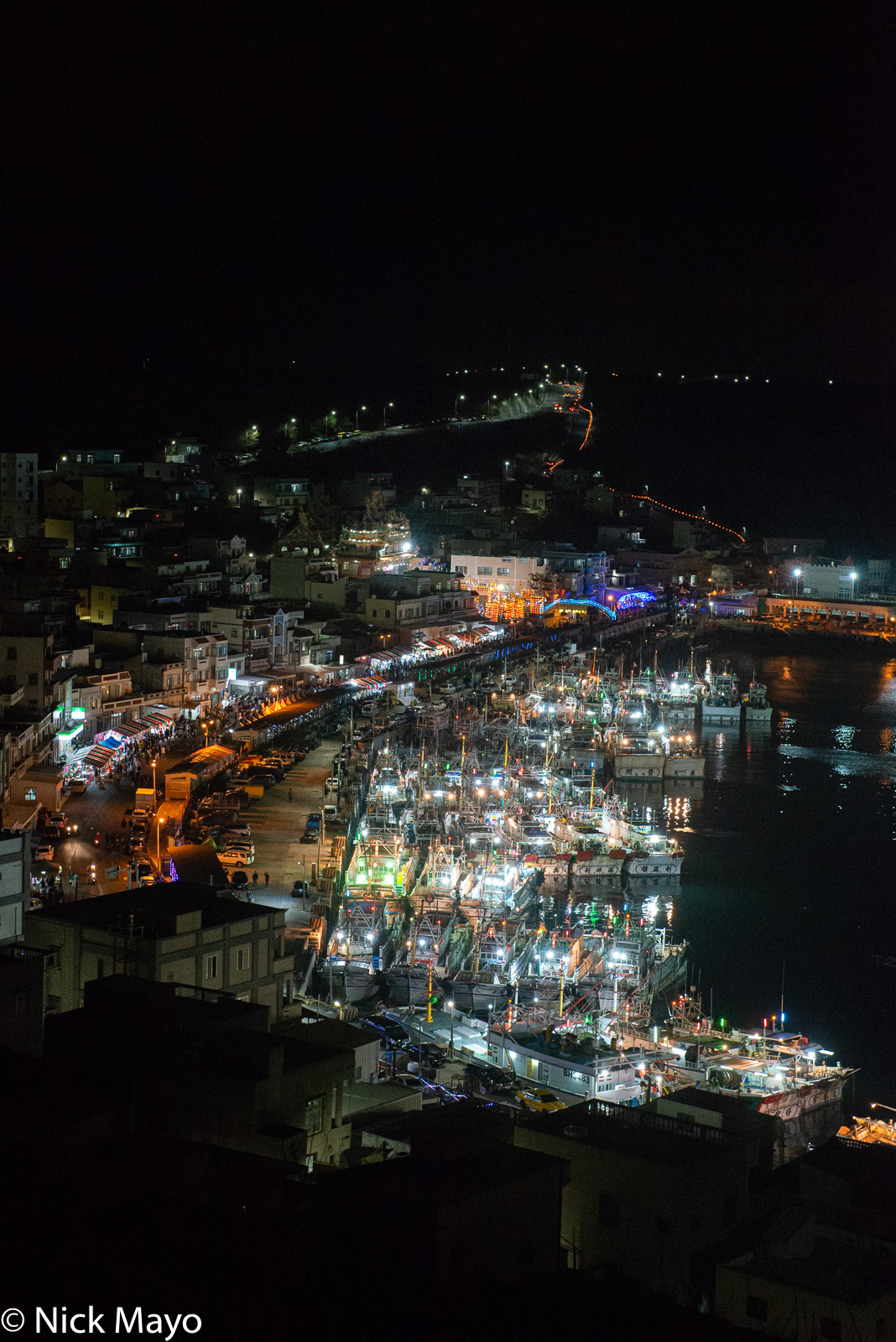 Fishing boats in Wai'an harbour lit up for a festival.
