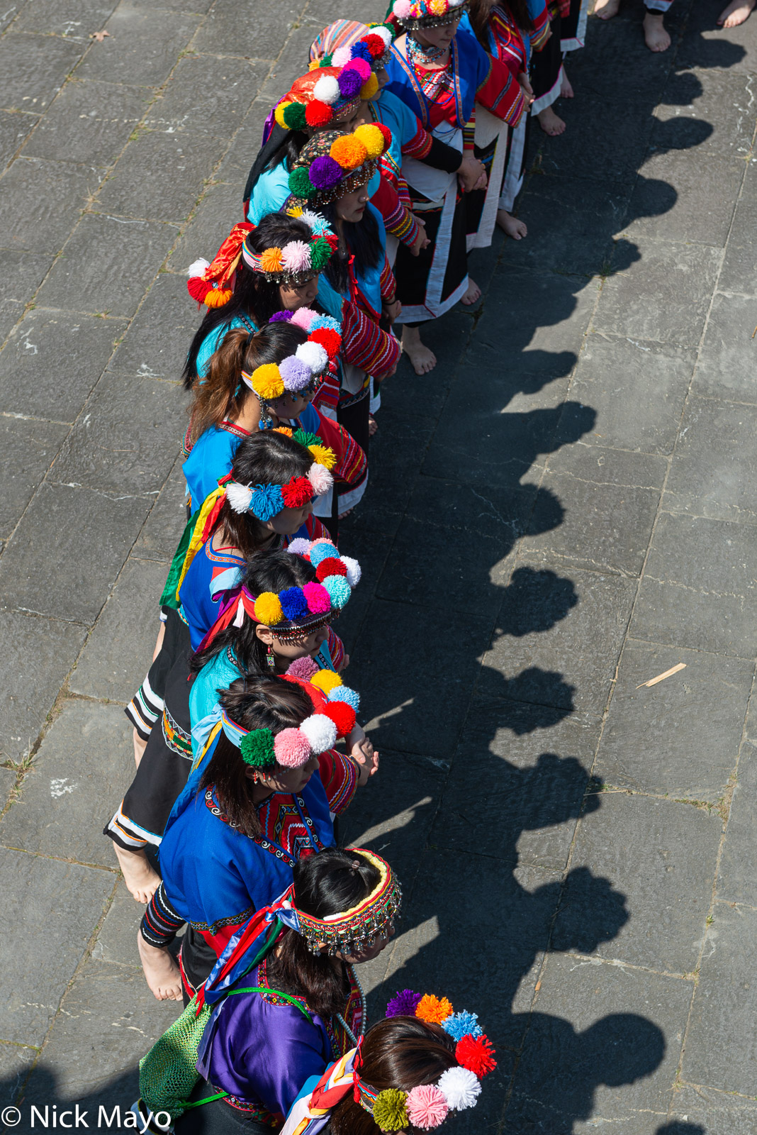 Pom pom shadows on the paving during the women's dance at the Tsou Mayasvi festival in Tefuye.