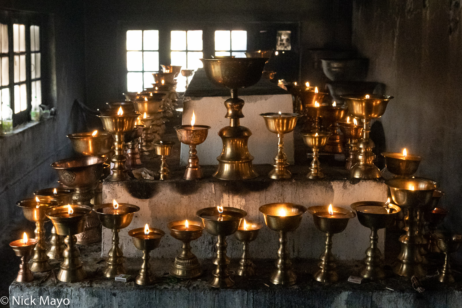 Butter lamps lit as votive offerings at Hemis monastery.