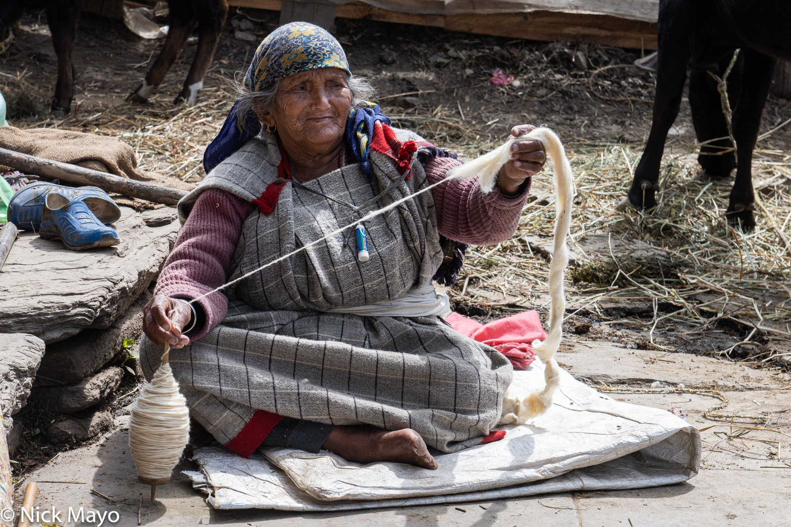 A Kulu woman spinning wool on a hand held spindle in the village of Rumsu.